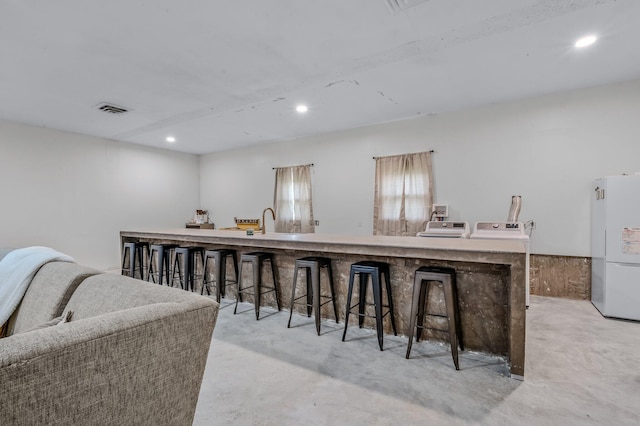 kitchen featuring a kitchen bar and white fridge