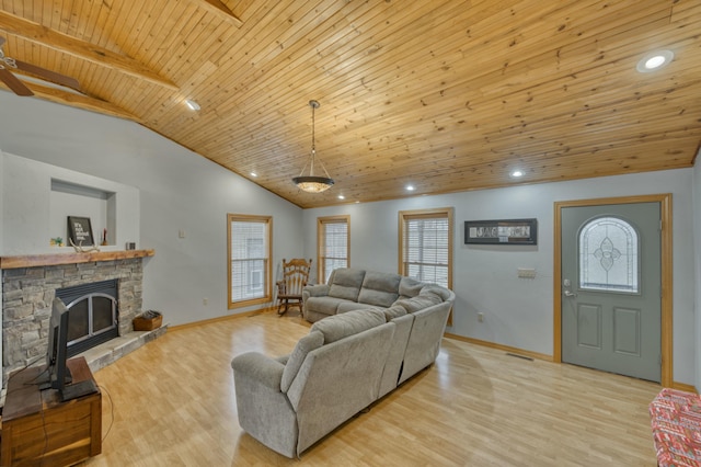 living room featuring lofted ceiling with beams, light wood-type flooring, a fireplace, and wood ceiling