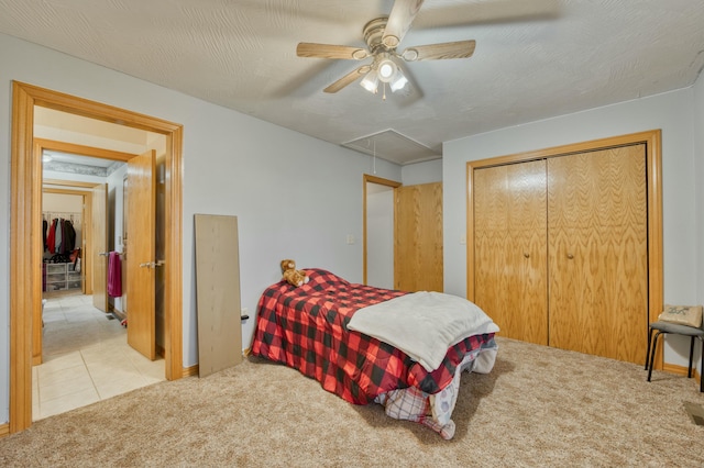 bedroom with light colored carpet, a textured ceiling, and ceiling fan