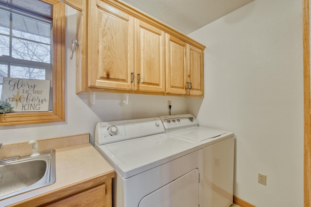 laundry room featuring cabinets, sink, and independent washer and dryer