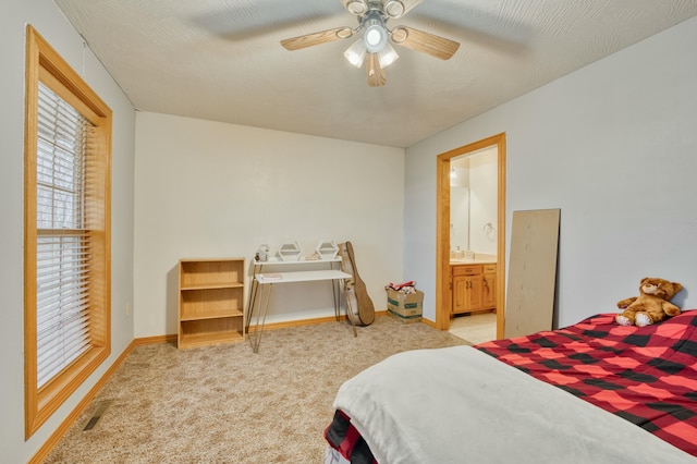 carpeted bedroom featuring ceiling fan and ensuite bath