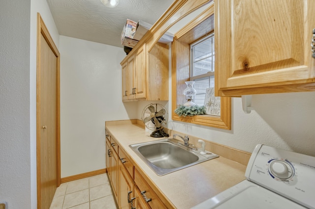 laundry room with sink, light tile patterned floors, washer / clothes dryer, and cabinets