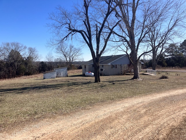 exterior space with a storage unit and a front lawn