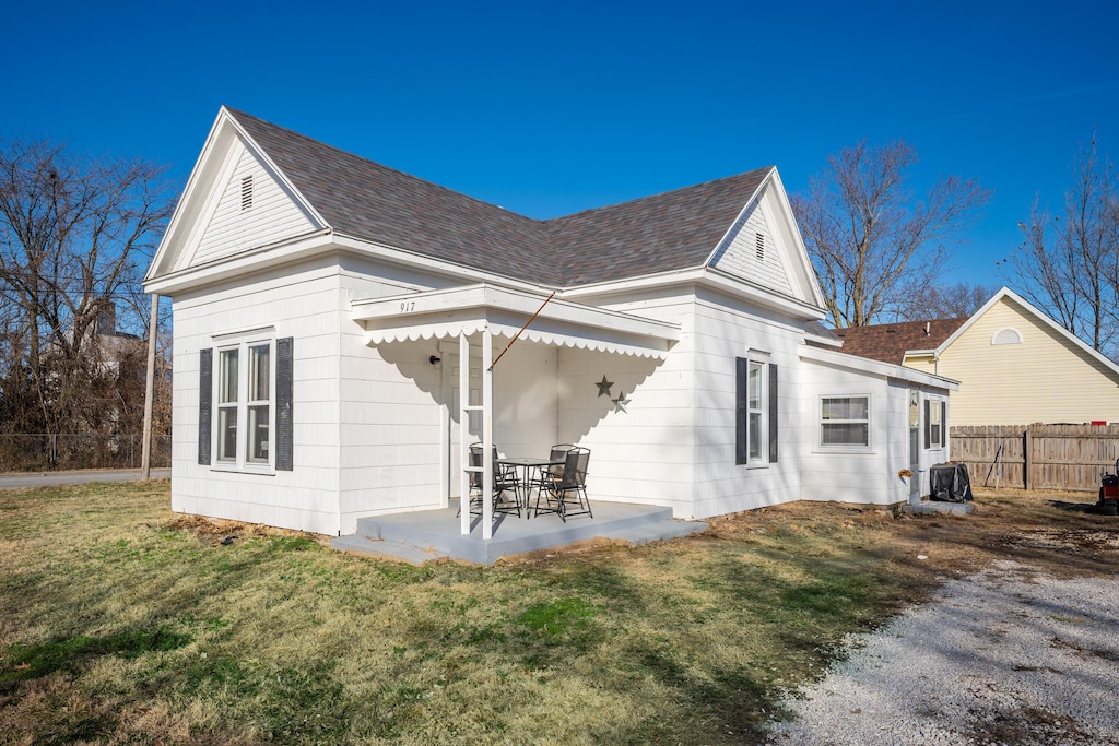 back of property featuring a patio and a yard