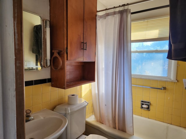 full bathroom with tasteful backsplash, sink, tile walls, shower / tub combo, and toilet