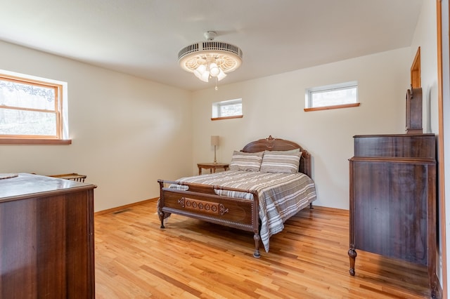 bedroom with light hardwood / wood-style floors and multiple windows