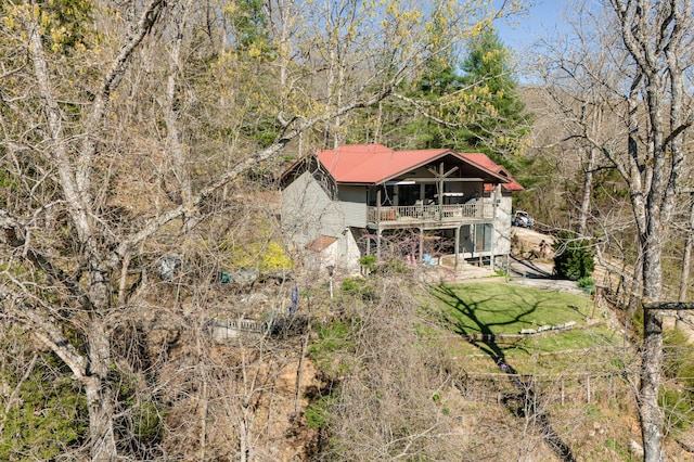 rear view of house with a balcony and a yard