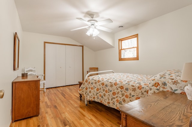 bedroom with light hardwood / wood-style flooring, a closet, ceiling fan, and vaulted ceiling