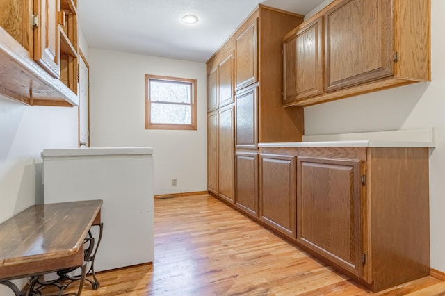 kitchen with refrigerator and light wood-type flooring