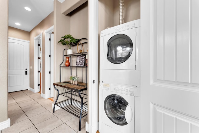 laundry room with stacked washer / dryer and light tile patterned floors