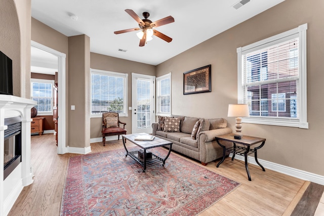 living room with ceiling fan, a healthy amount of sunlight, and light hardwood / wood-style floors