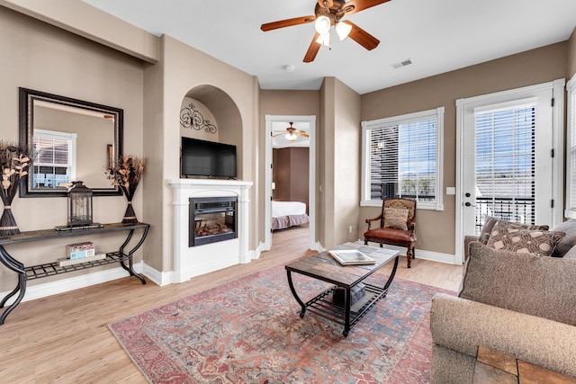 living room with light hardwood / wood-style flooring and ceiling fan