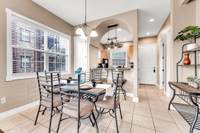 dining area with light tile patterned floors and a notable chandelier