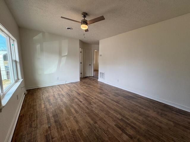 unfurnished room with ceiling fan, dark hardwood / wood-style floors, and a textured ceiling