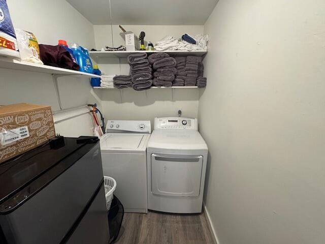 laundry area featuring washer and dryer and dark wood-type flooring