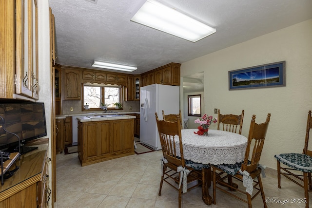 dining space featuring a textured ceiling and light tile patterned floors