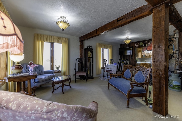 living room with beamed ceiling, ornate columns, a textured ceiling, and carpet flooring