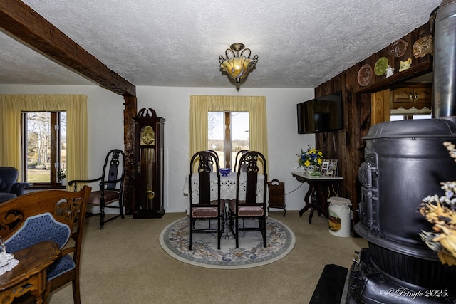 carpeted dining area with beamed ceiling, an inviting chandelier, and a textured ceiling