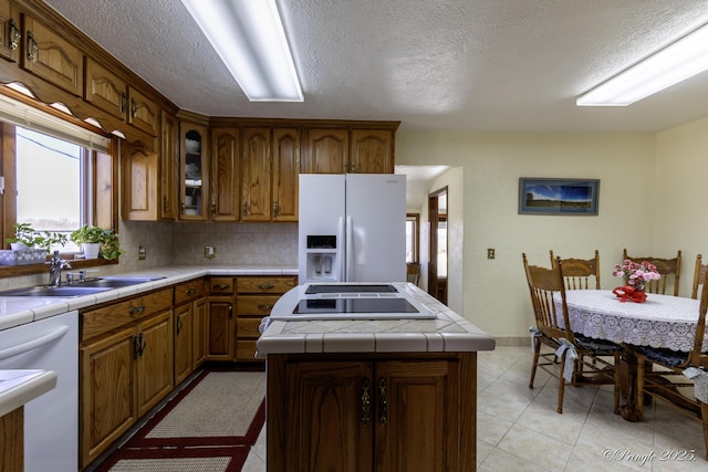 kitchen featuring sink, white appliances, tile counters, and a kitchen island