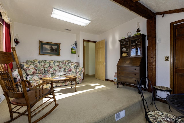 living room featuring beamed ceiling, carpet floors, and a textured ceiling