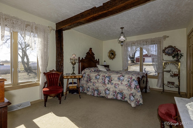 bedroom with a textured ceiling, light colored carpet, and beamed ceiling