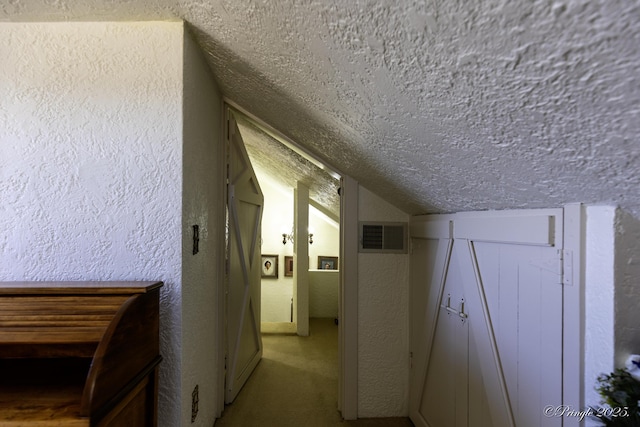 interior space featuring carpet floors, a textured ceiling, and vaulted ceiling