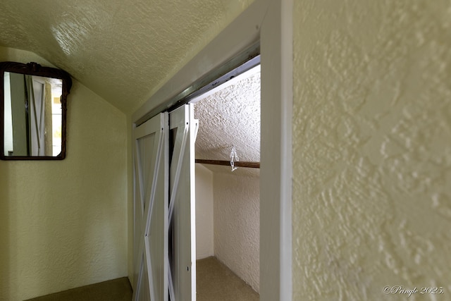 interior space with vaulted ceiling and a textured ceiling