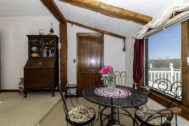 carpeted dining space with vaulted ceiling with beams and a textured ceiling