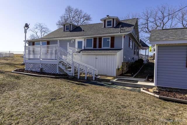 view of front facade with a wooden deck and a front yard