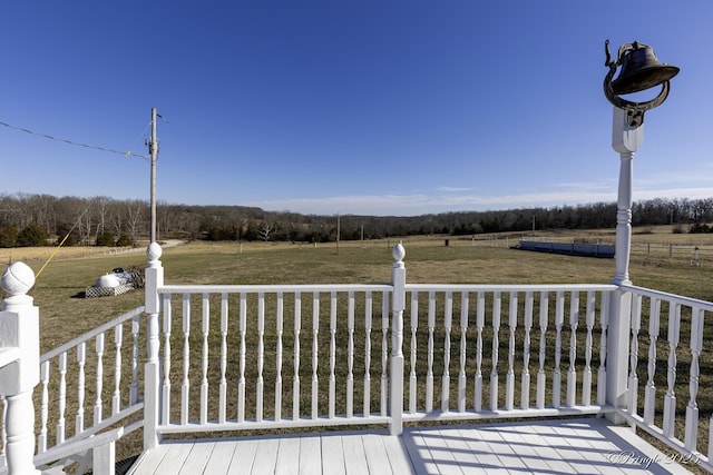 wooden terrace featuring a yard and a rural view