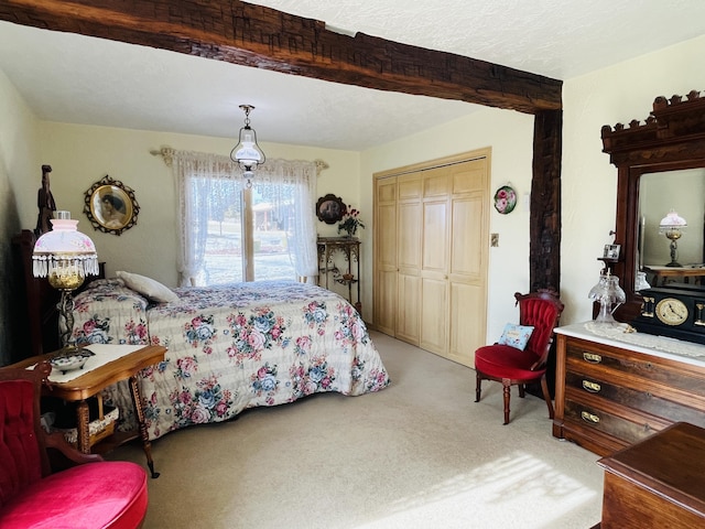 bedroom with light carpet, beam ceiling, and a closet