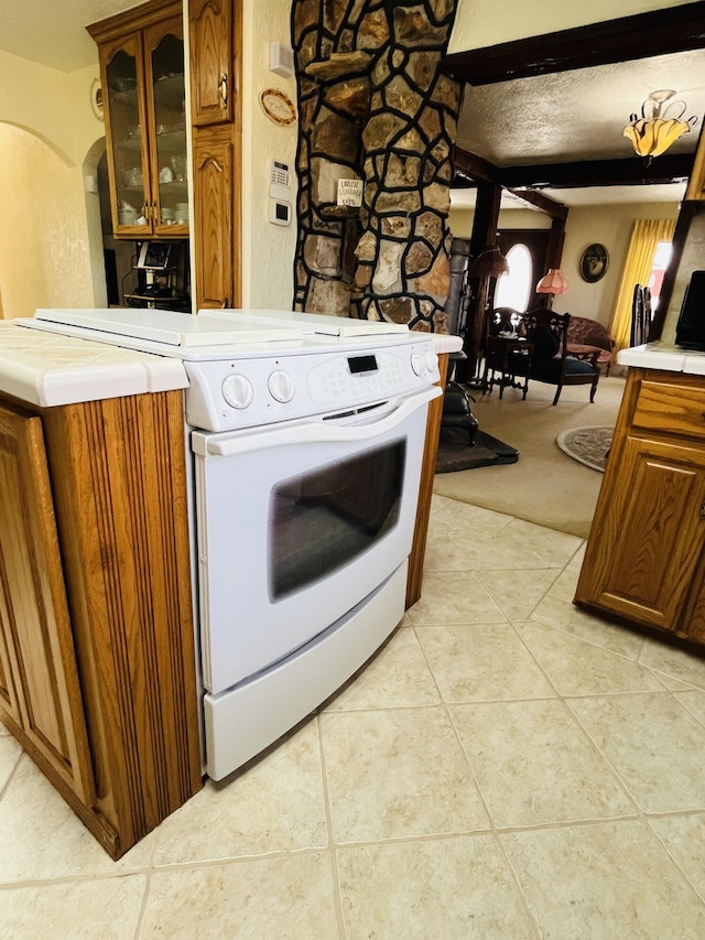 kitchen with white electric range, tile countertops, and light tile patterned flooring