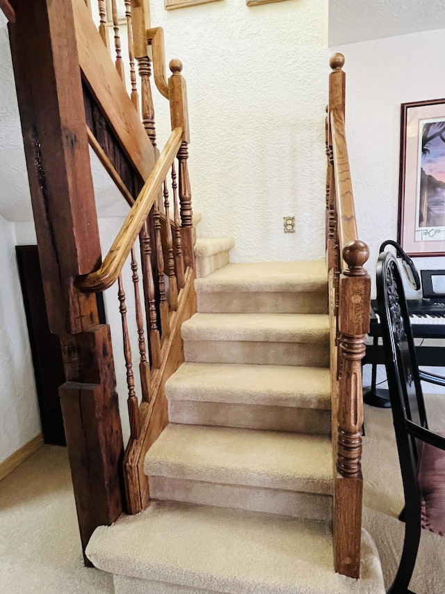 staircase featuring carpet flooring