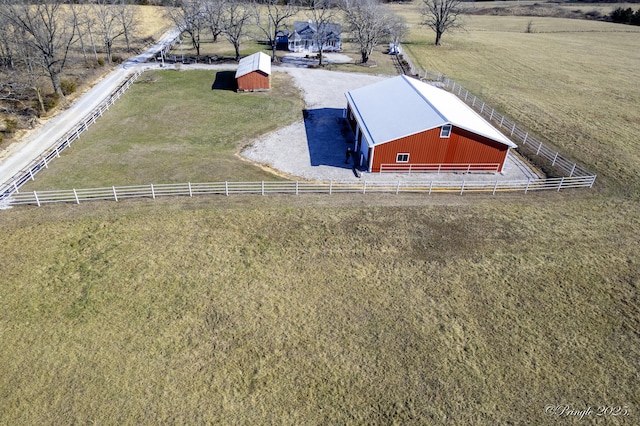 entry to storm shelter featuring a yard, an outdoor structure, and a rural view