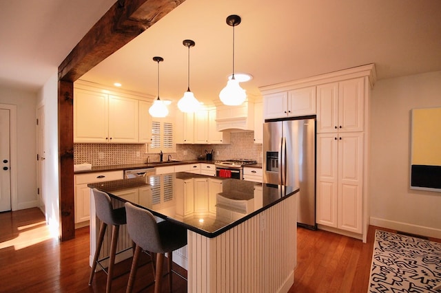 kitchen with white cabinetry, stainless steel appliances, a center island, and sink