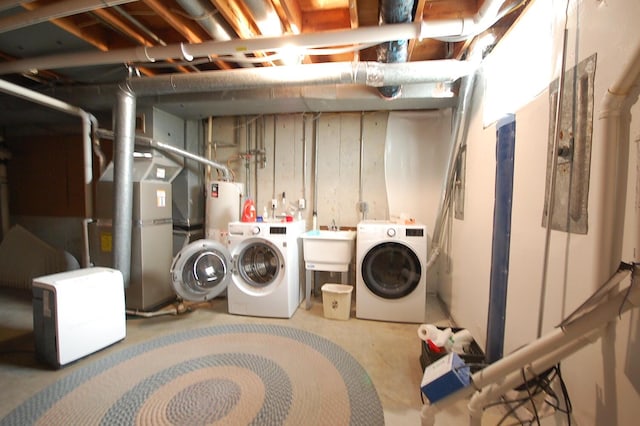 laundry area featuring sink, washing machine and dryer, and water heater