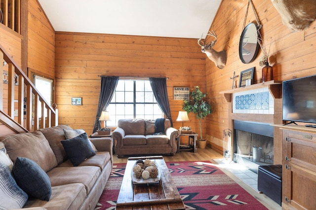 living room featuring lofted ceiling and wooden walls