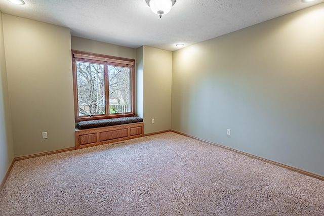 carpeted spare room featuring a textured ceiling