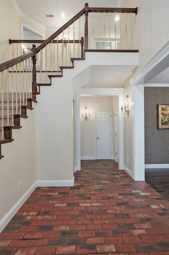 foyer with a high ceiling and crown molding