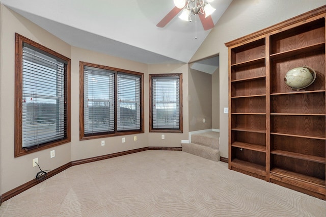 carpeted spare room with lofted ceiling and ceiling fan