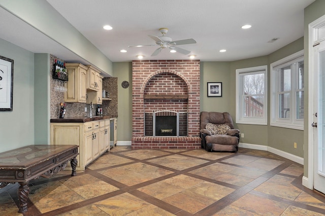 living room with ceiling fan, sink, and a brick fireplace