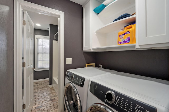 washroom featuring cabinets and washing machine and dryer