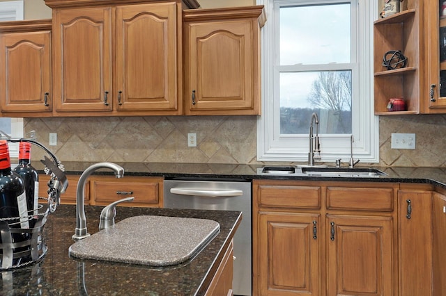 kitchen featuring dark stone counters, dishwasher, sink, and backsplash