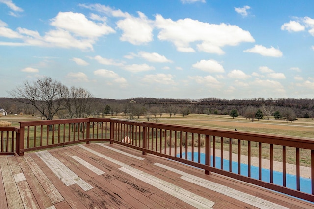 wooden terrace with a pool and a rural view