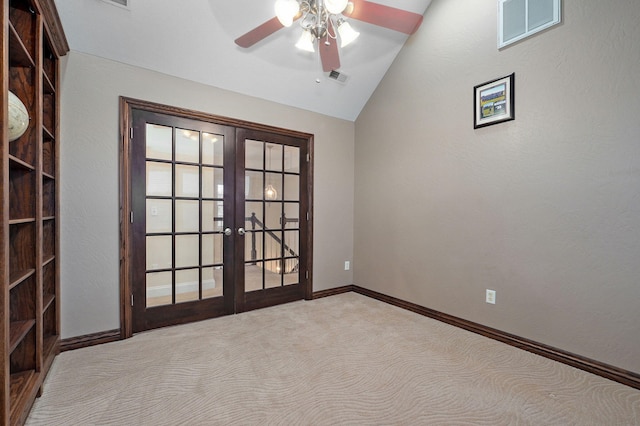 carpeted empty room featuring lofted ceiling, ceiling fan, and french doors