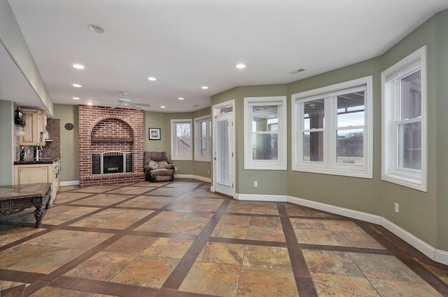 living room with ceiling fan and a brick fireplace