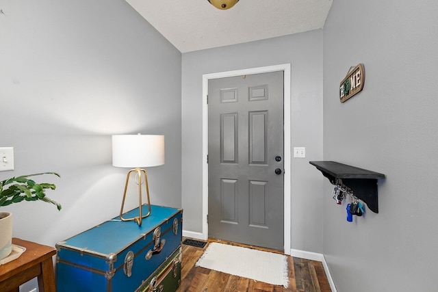 foyer with dark hardwood / wood-style floors and a textured ceiling