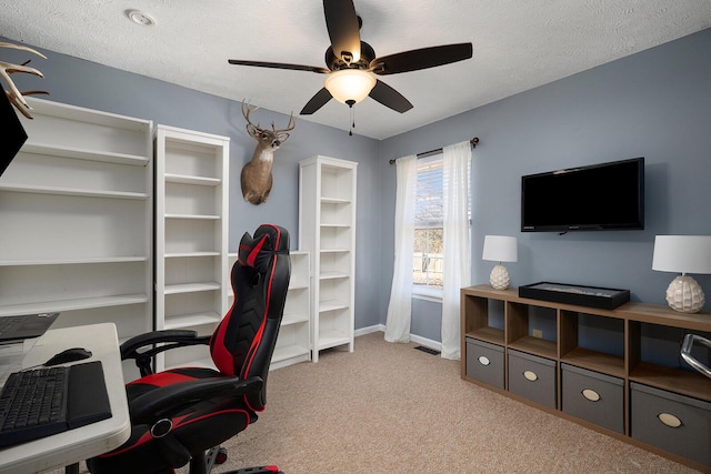 office featuring ceiling fan, light colored carpet, and a textured ceiling