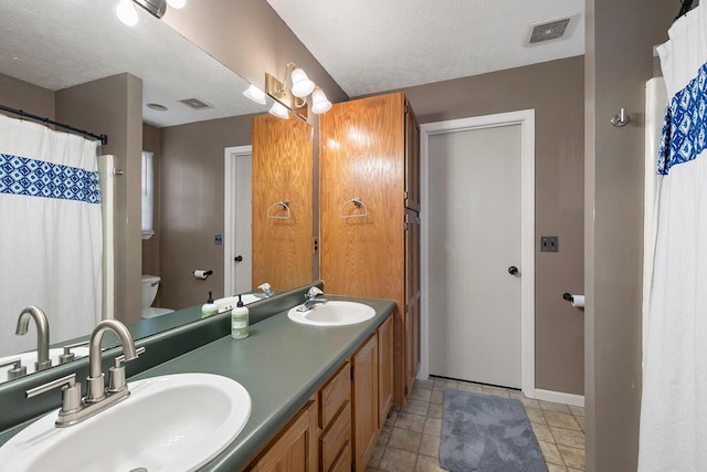 bathroom featuring vanity, toilet, and a textured ceiling