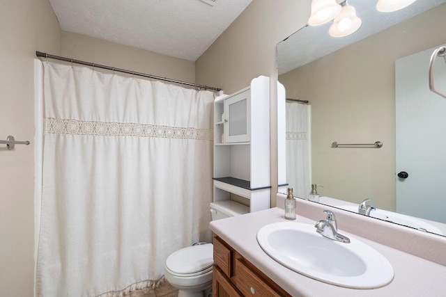 bathroom featuring vanity, toilet, and a textured ceiling